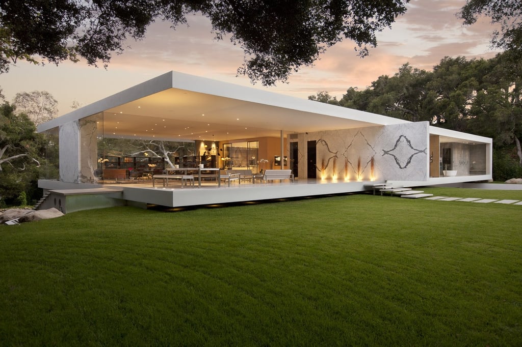 A house with a grass field with Farnsworth House in the background