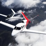 A close up of a propeller plane that is flying in the sky