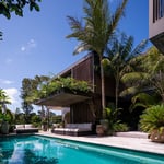 A pool next to a palm tree in front of a building