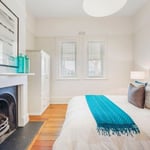 A living room with a bed and a fireplace