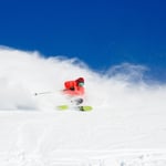 A man riding skis down a snow covered slope