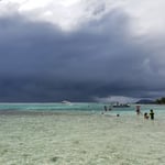 A group of people on a beach near a body of water