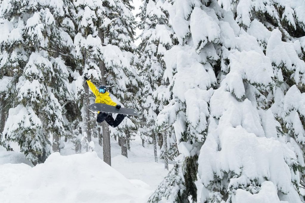 A man flying through the air on a snow covered slope