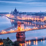 A long bridge over a body of water with a city in the background