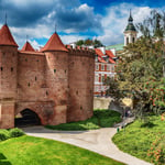 A large brick building with grass in front of a castle