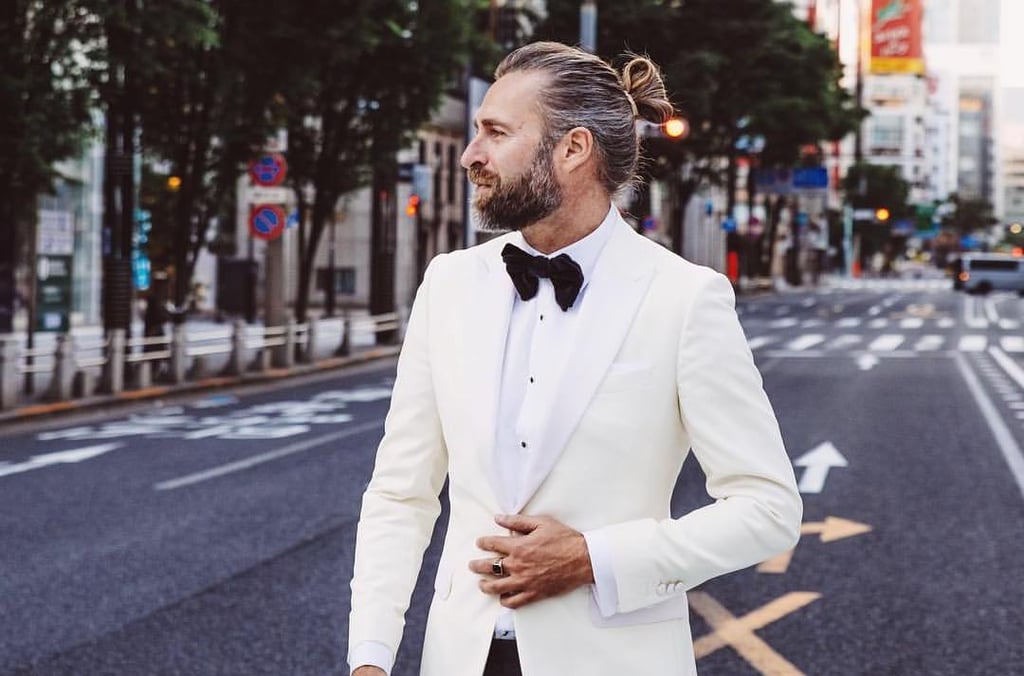 A man wearing a suit and tie walking down the street