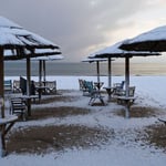 A group of lawn chairs sitting on top of a sandy beach