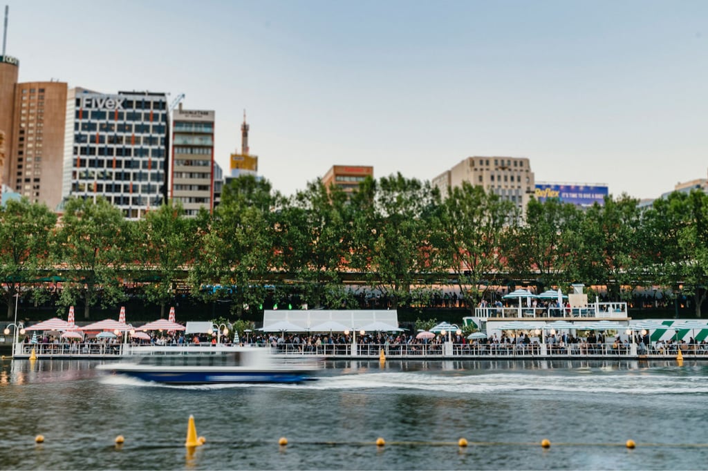 A small boat in a body of water with a city in the background