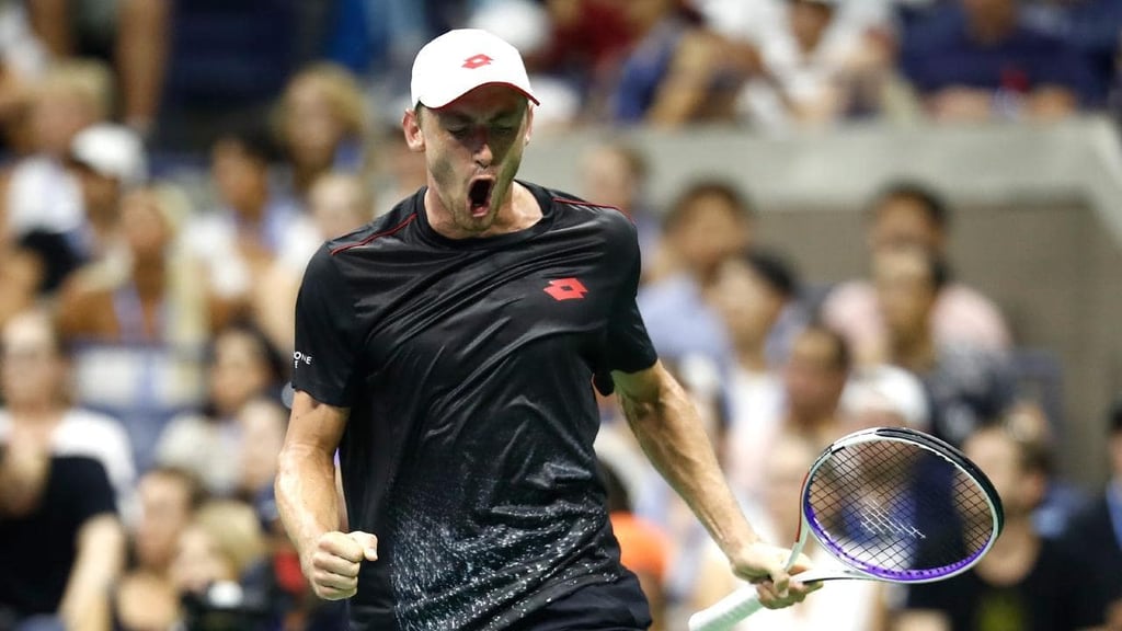 A man with a racket in front of a crowd