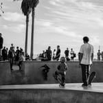 A group of people watching a man doing a trick on a skateboard