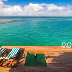 A row of lawn chairs sitting on top of a beach