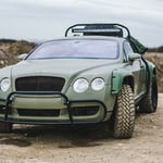 A car parked on the side of a dirt field