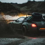 A car parked on the side of a dirt road