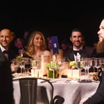 A group of people sitting at a table with wine glasses