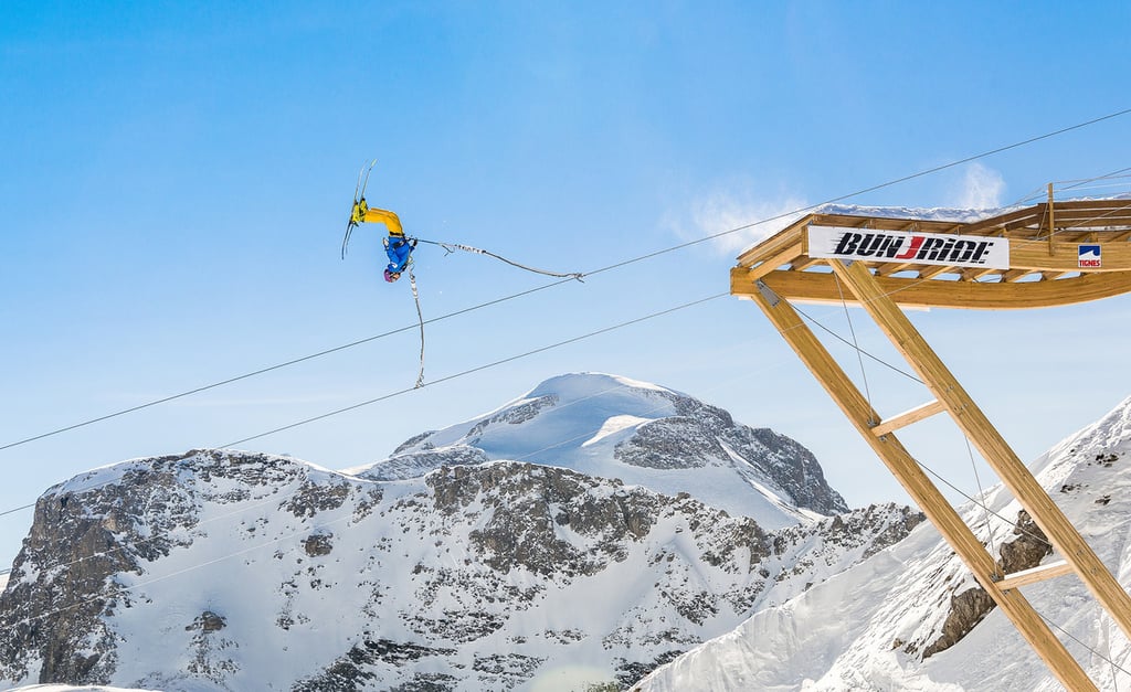 A man flying through the air on a snow covered slope