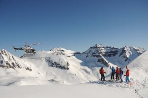 A group of people standing on top of a snow covered slope