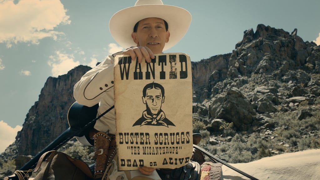 A man holding a sign in front of a mountain