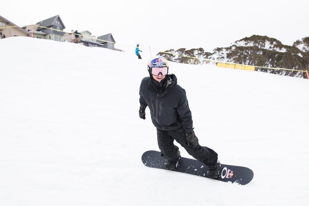 A man riding a snowboard down a snow covered slope