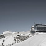 A group of people riding skis across snow covered ground