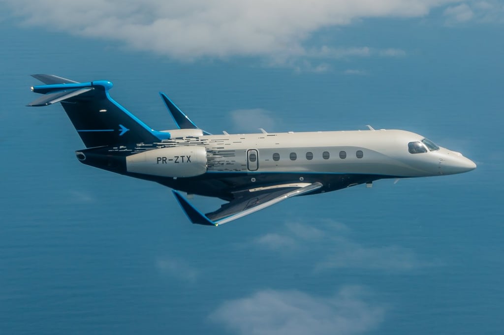 A large passenger jet flying through a cloudy blue sky