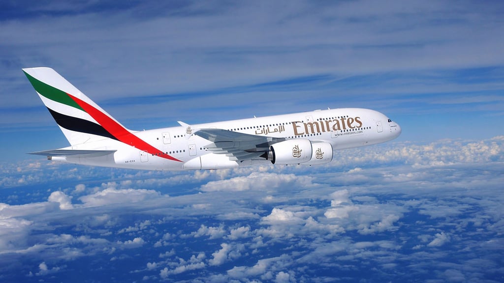 A large passenger jet flying through a cloudy blue sky