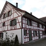 A small house in front of a brick building