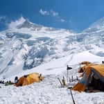 A person sitting on top of a snow covered mountain