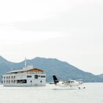 A small boat in a body of water with a mountain in the background