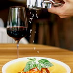 A close up of a plate of food and a glass of wine