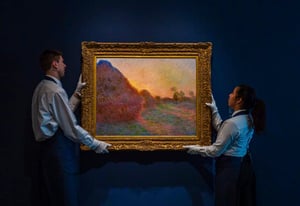 A man and a woman standing in front of a painting