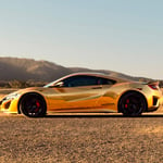 A car parked on the side of a dirt field