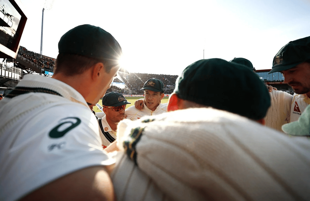 A group of people sitting around a baseball field