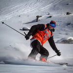 A man riding skis down a snow covered slope