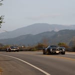 A car driving on a road with a mountain in the background