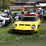 A group of people sitting around a car