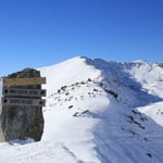 A man riding on top of a snow covered mountain