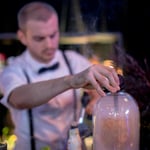 A person holding a glass of beer on a table