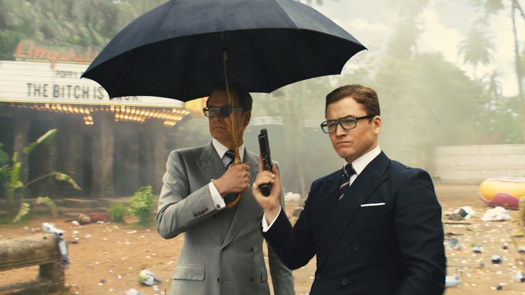 A man in a suit holding an umbrella
