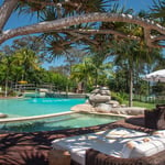 A group of lawn chairs sitting next to a pool of water