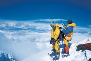 A man standing on top of a snow covered mountain