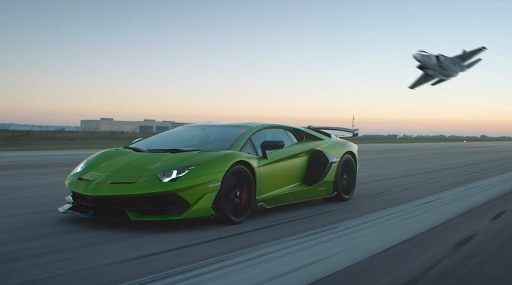 A plane sitting on top of a green car on the road