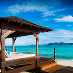 A chair sitting in front of a beach next to the ocean