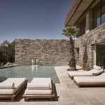 A stone building that has a bench in front of a fireplace