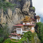 A view of a stone mountain with Paro Taktsang in the background