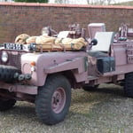 A truck is parked in front of a car