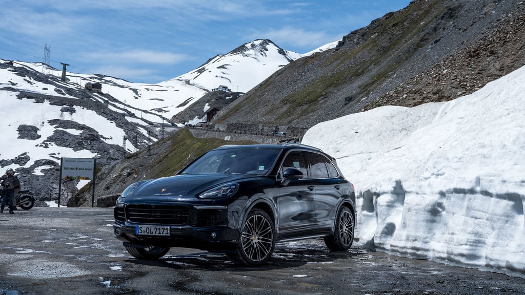 A car parked on the side of a snow covered mountain