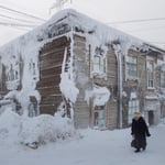 A man standing in a yard covered in snow