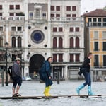 A group of people walking in front of a building