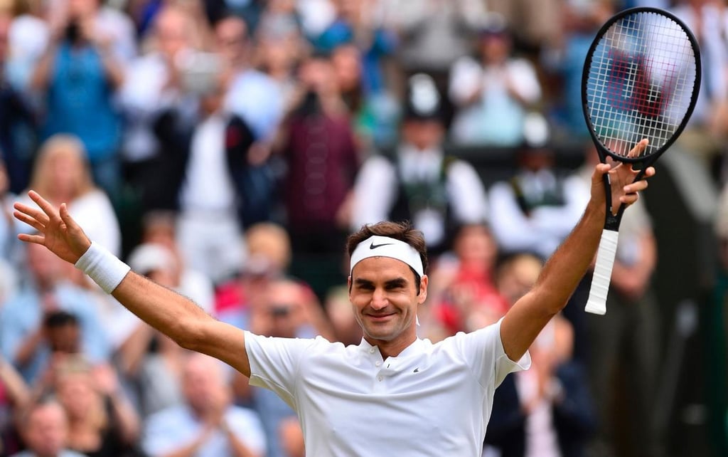 A man hitting a ball with a racket in front of a crowd