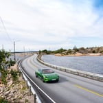 A car parked on the side of a road near a body of water